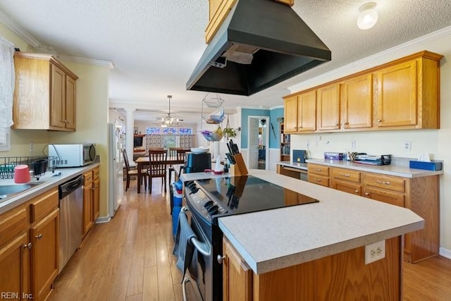 kitchen featuring a center island, ventilation hood, crown molding, appliances with stainless steel finishes, and light hardwood / wood-style floors