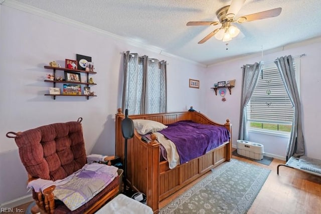 bedroom featuring hardwood / wood-style floors, a textured ceiling, ceiling fan, and crown molding