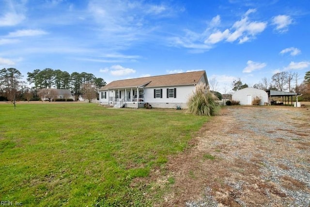 rear view of house with a lawn, a porch, and a carport