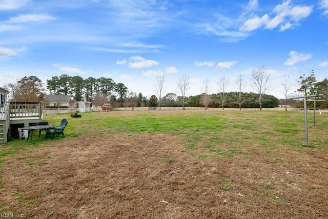 view of yard featuring a rural view and a wooden deck