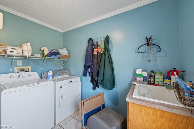 clothes washing area with washer and clothes dryer, sink, crown molding, light tile patterned floors, and a textured ceiling