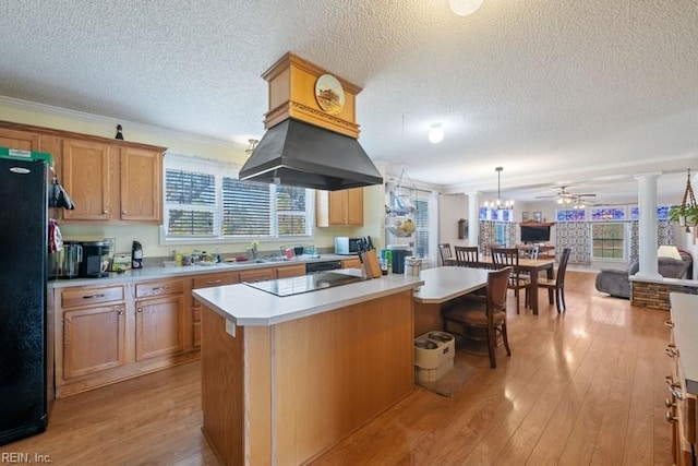 kitchen featuring ceiling fan, a center island, light hardwood / wood-style flooring, decorative light fixtures, and black appliances