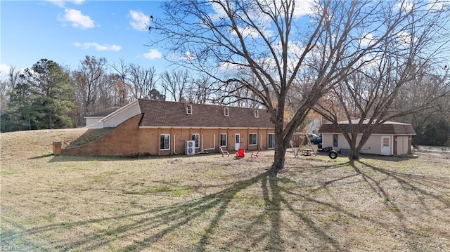 back of property featuring a yard and an outbuilding