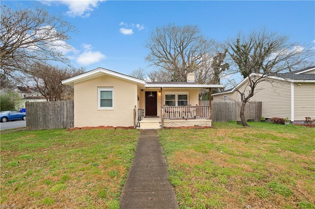 ranch-style house with a porch and a front lawn