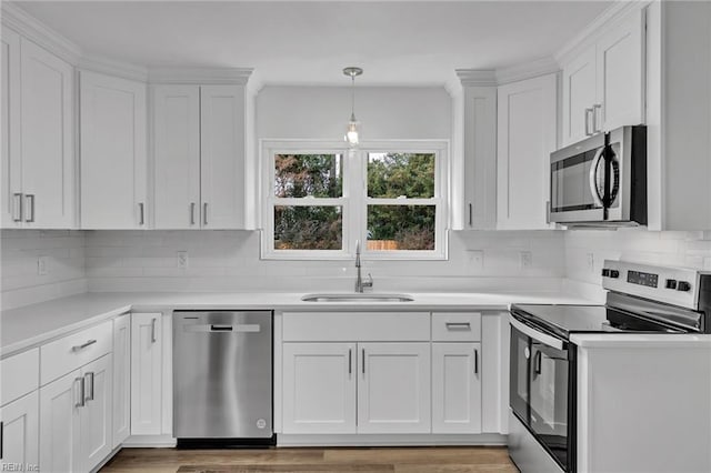 kitchen featuring hardwood / wood-style floors, appliances with stainless steel finishes, white cabinetry, and sink