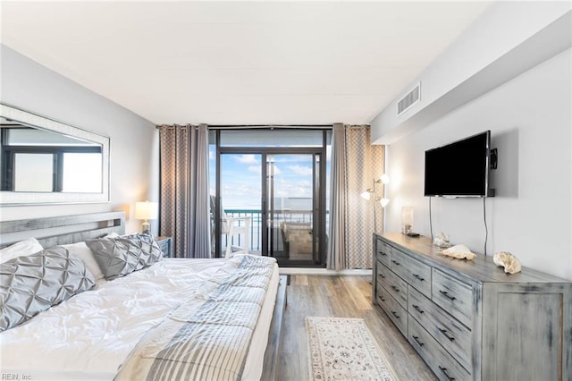 bedroom featuring light hardwood / wood-style floors, access to outside, and multiple windows