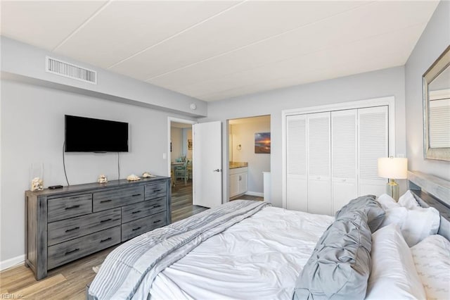 bedroom with connected bathroom, a closet, and light hardwood / wood-style flooring