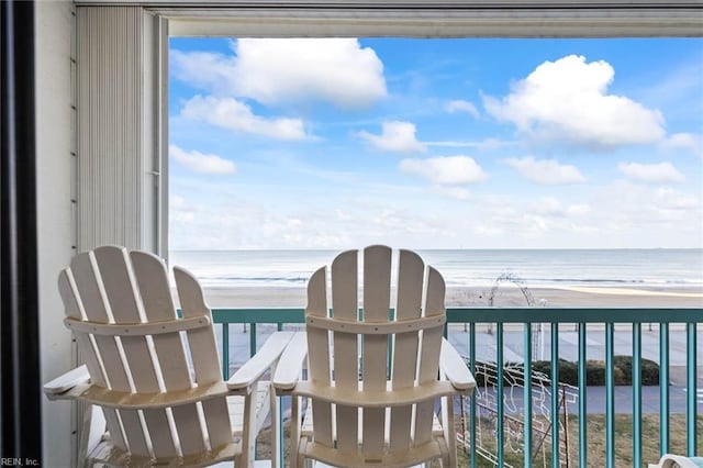 balcony with a water view and a view of the beach