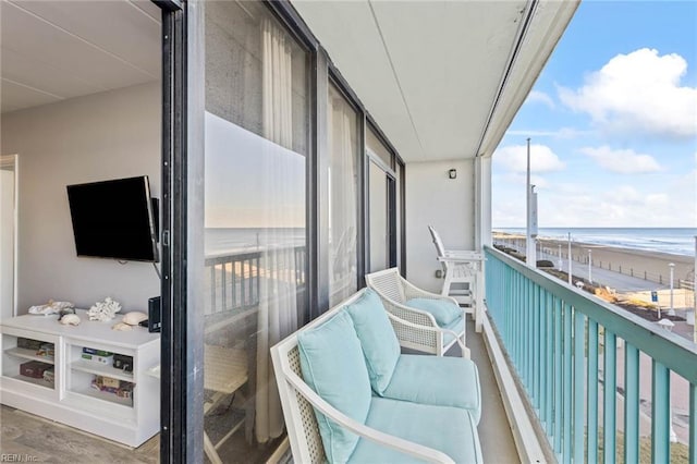 balcony featuring a water view and a beach view