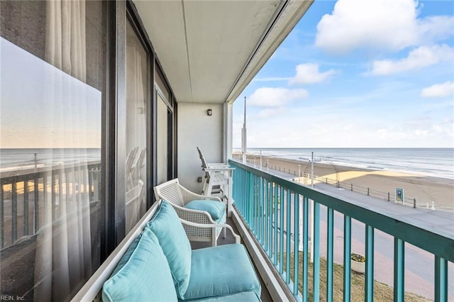 balcony featuring a water view and a beach view