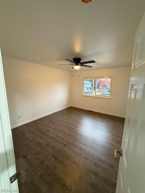 unfurnished room with dark hardwood / wood-style flooring and ceiling fan