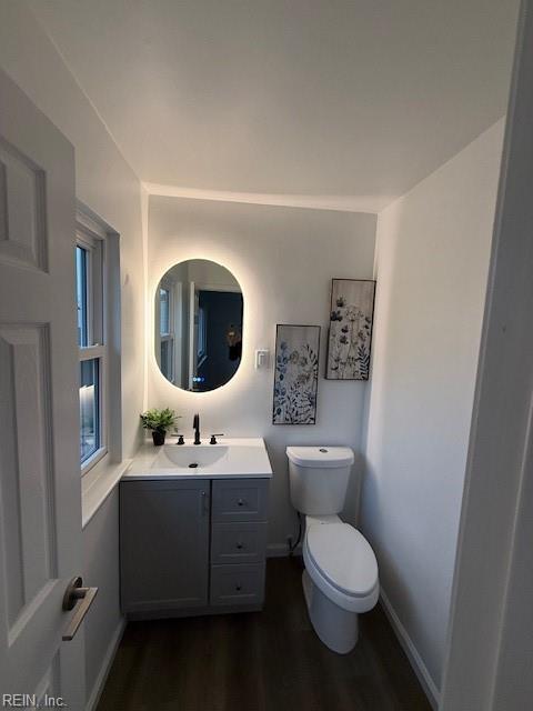 bathroom with toilet, vanity, and hardwood / wood-style flooring