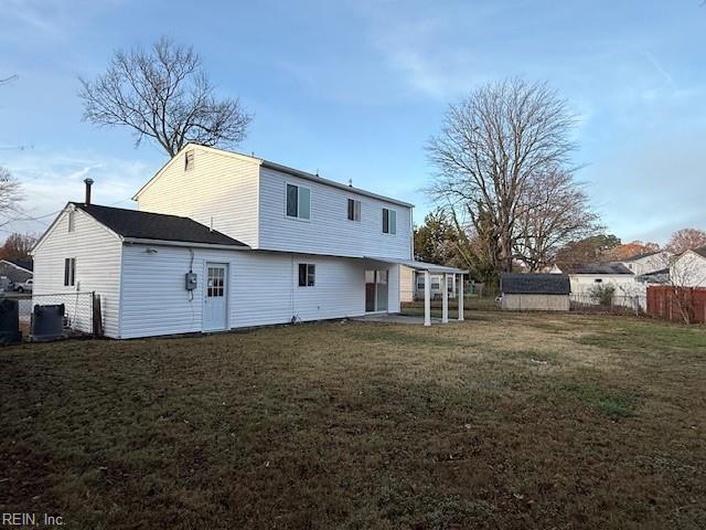 back of house featuring a lawn and a patio