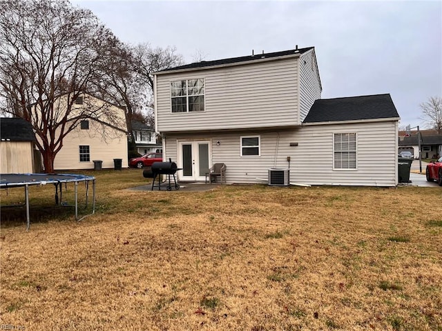 back of property featuring a yard, a patio, a trampoline, and cooling unit