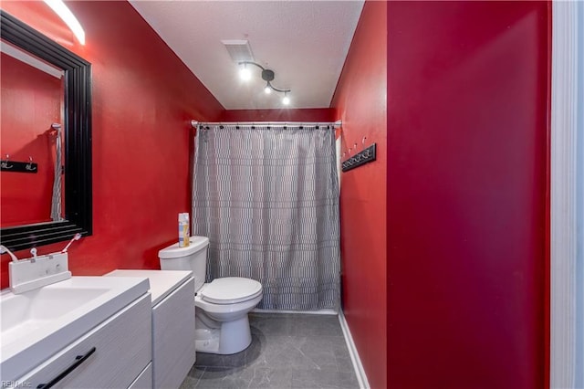 bathroom featuring vanity, toilet, and curtained shower