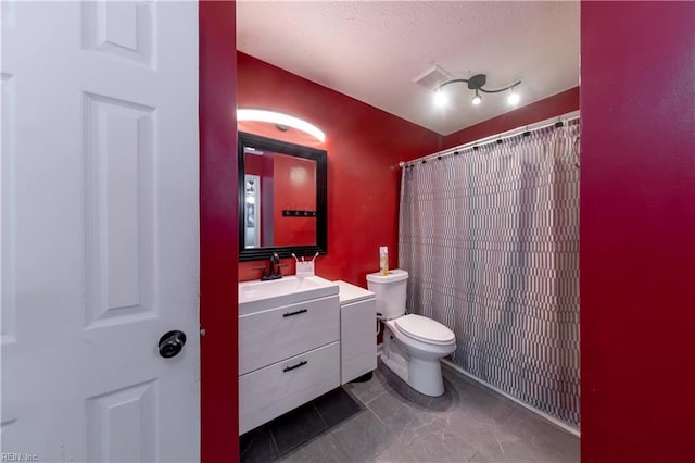 bathroom featuring a shower with curtain, vanity, toilet, and a textured ceiling