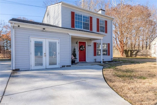 view of front of house featuring a front yard and french doors