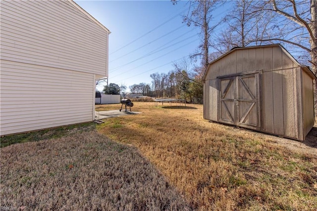 view of yard with a trampoline and a shed