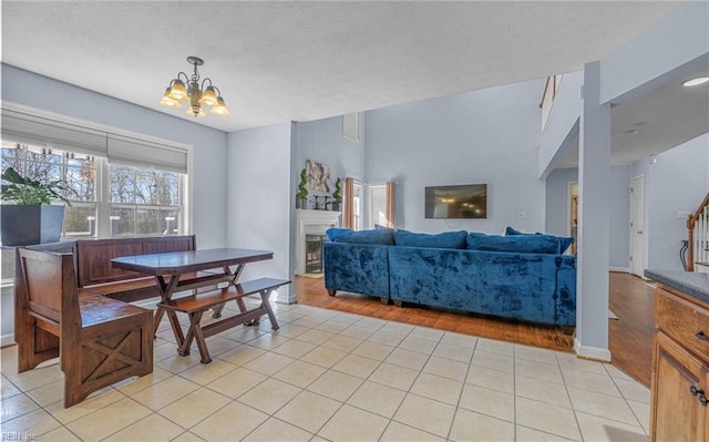 dining area with light hardwood / wood-style flooring, a textured ceiling, and a notable chandelier