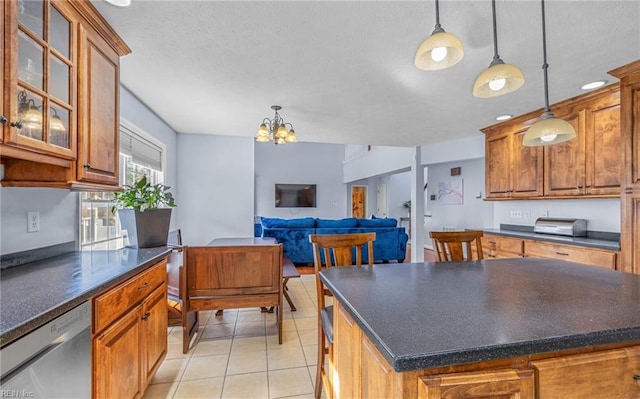 kitchen featuring an inviting chandelier, dishwasher, a kitchen island, hanging light fixtures, and light tile patterned flooring