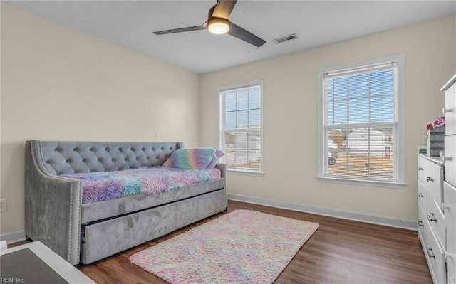 bedroom with dark hardwood / wood-style flooring, multiple windows, and ceiling fan