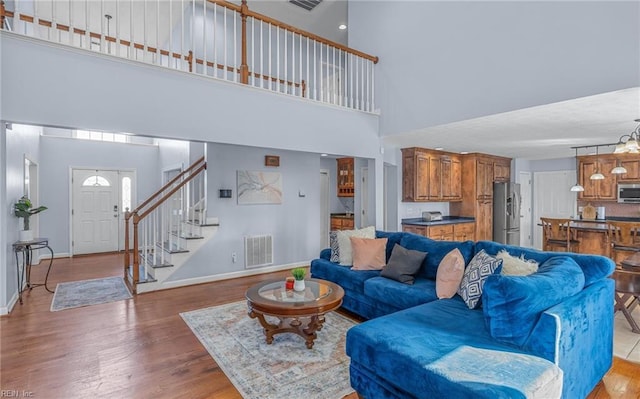 living room featuring a high ceiling and light hardwood / wood-style floors