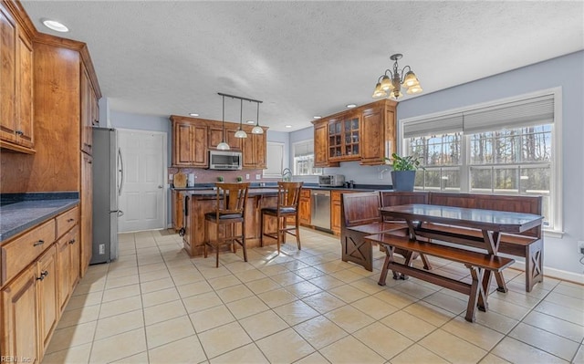 kitchen featuring a chandelier, appliances with stainless steel finishes, a kitchen island, and hanging light fixtures