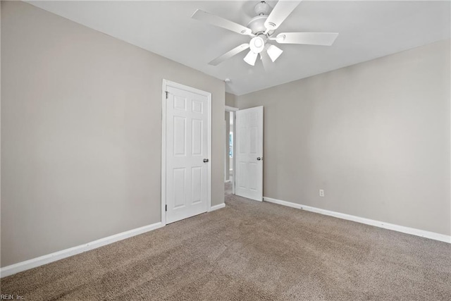 carpeted spare room featuring ceiling fan