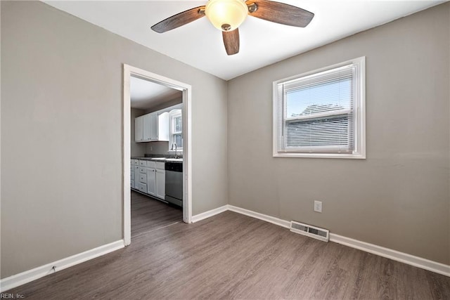 empty room featuring ceiling fan, dark hardwood / wood-style flooring, and sink