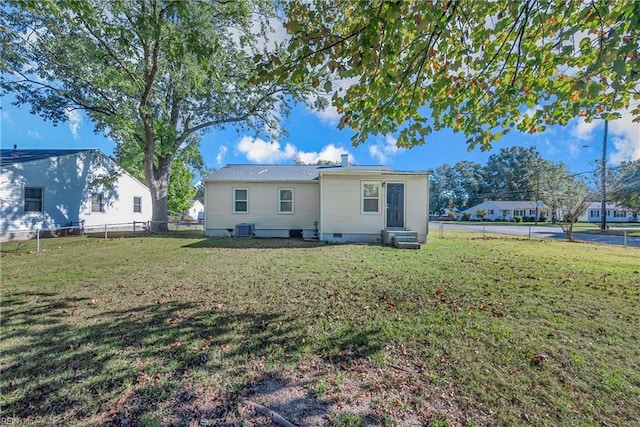 rear view of house with a lawn and central air condition unit