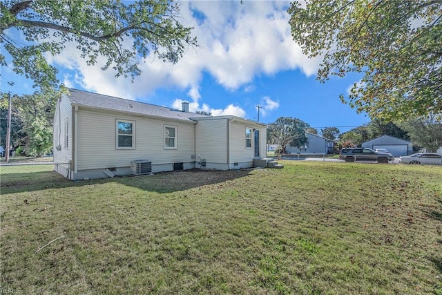 rear view of property with a lawn and cooling unit