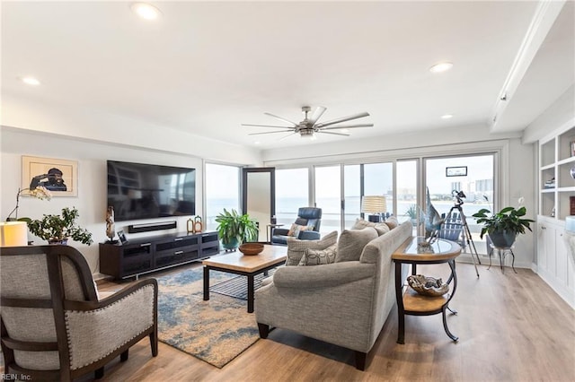 living room featuring light wood-type flooring and ceiling fan