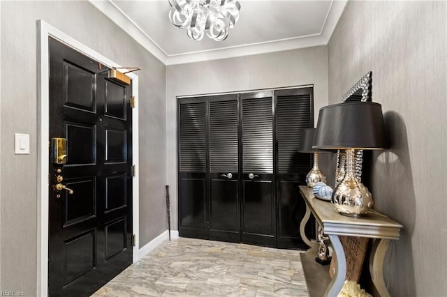 entryway with a chandelier and ornamental molding