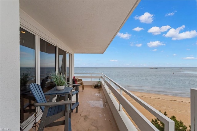 balcony with a water view and a view of the beach