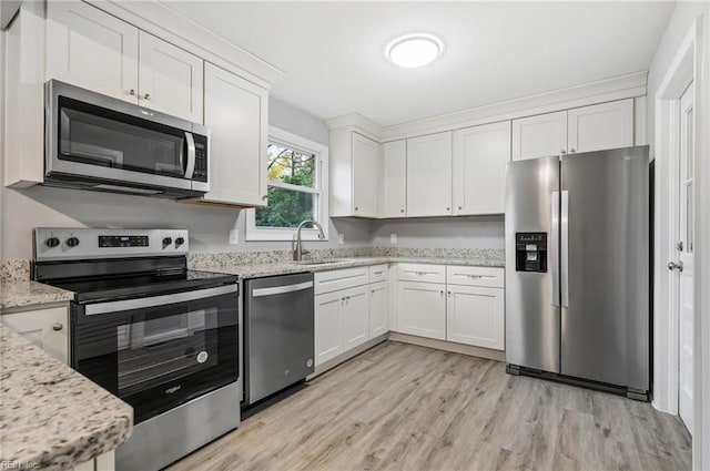 kitchen featuring white cabinets, sink, appliances with stainless steel finishes, and light hardwood / wood-style flooring