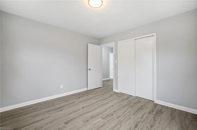 unfurnished bedroom with a closet and light hardwood / wood-style flooring