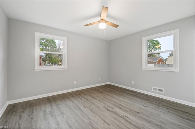 unfurnished room featuring wood-type flooring, ceiling fan, and a healthy amount of sunlight