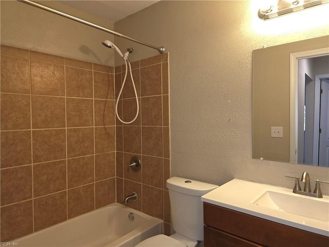 full bathroom featuring vanity, tiled shower / bath combo, and toilet