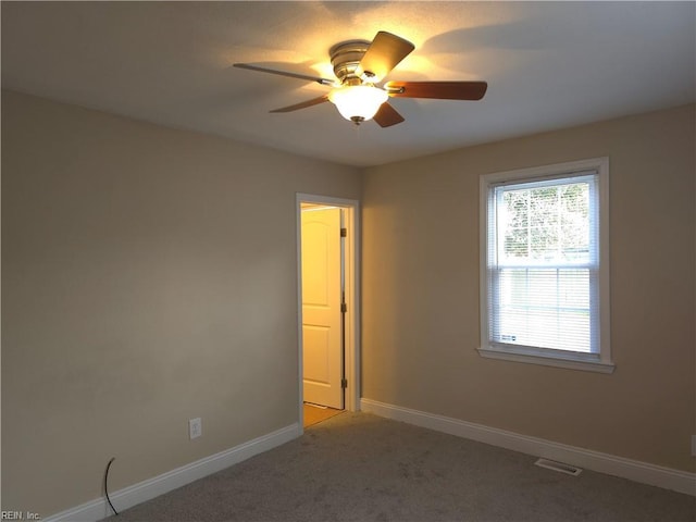 carpeted spare room featuring ceiling fan