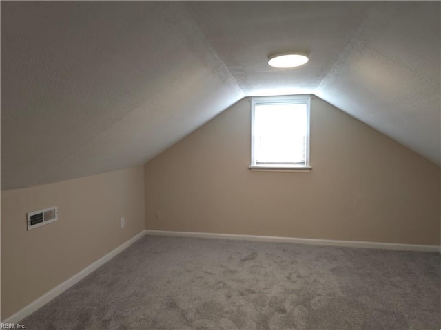 bonus room with carpet floors and lofted ceiling