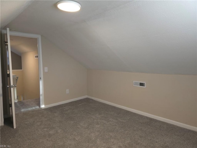 bonus room featuring dark colored carpet and vaulted ceiling