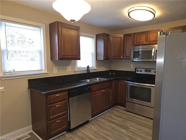 kitchen with plenty of natural light, sink, wood-type flooring, and stainless steel appliances