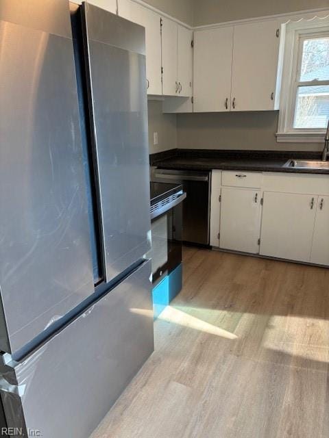 kitchen featuring sink, white cabinets, stainless steel appliances, and light hardwood / wood-style floors