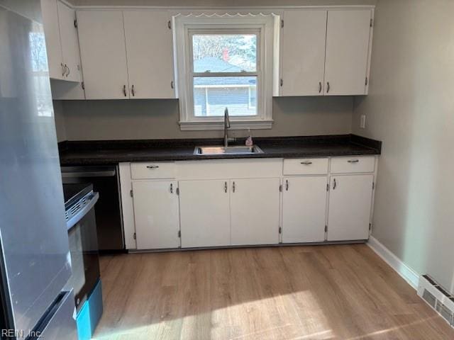 kitchen featuring white cabinets, light wood-type flooring, sink, and appliances with stainless steel finishes