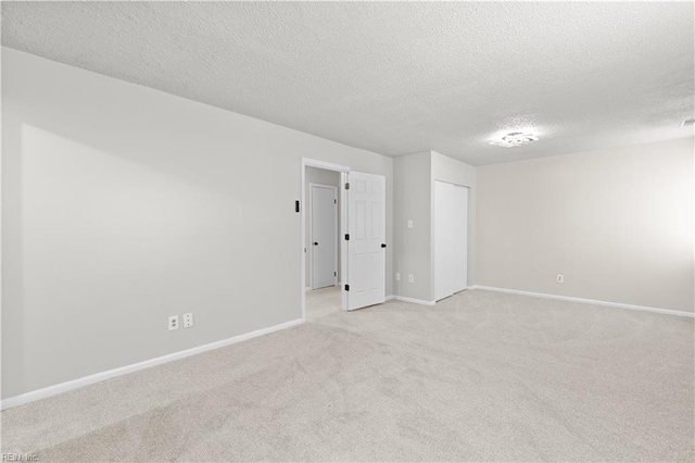 empty room featuring light carpet and a textured ceiling