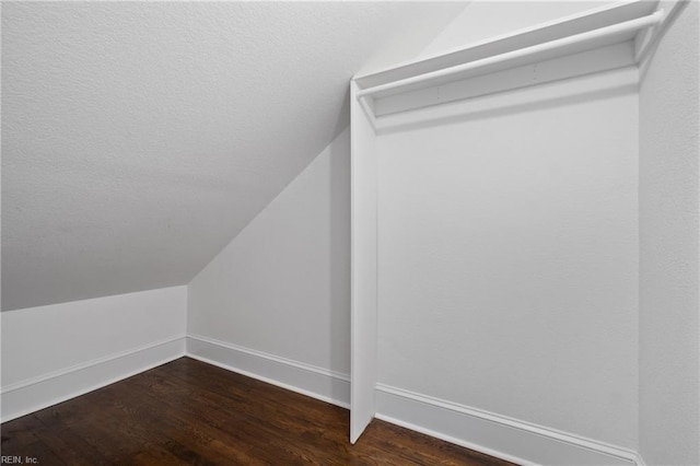 walk in closet featuring dark hardwood / wood-style floors and lofted ceiling