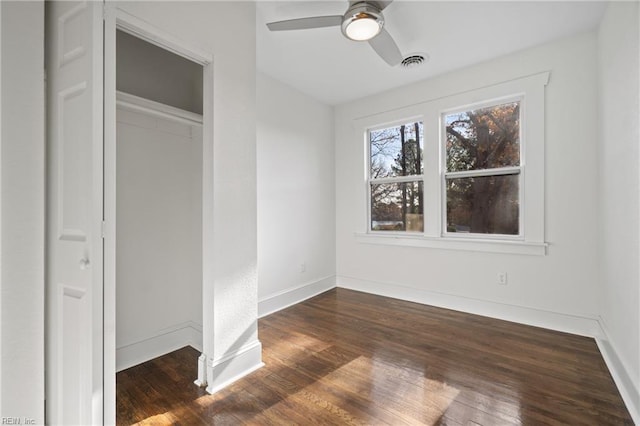 unfurnished bedroom featuring dark hardwood / wood-style flooring, a closet, and ceiling fan