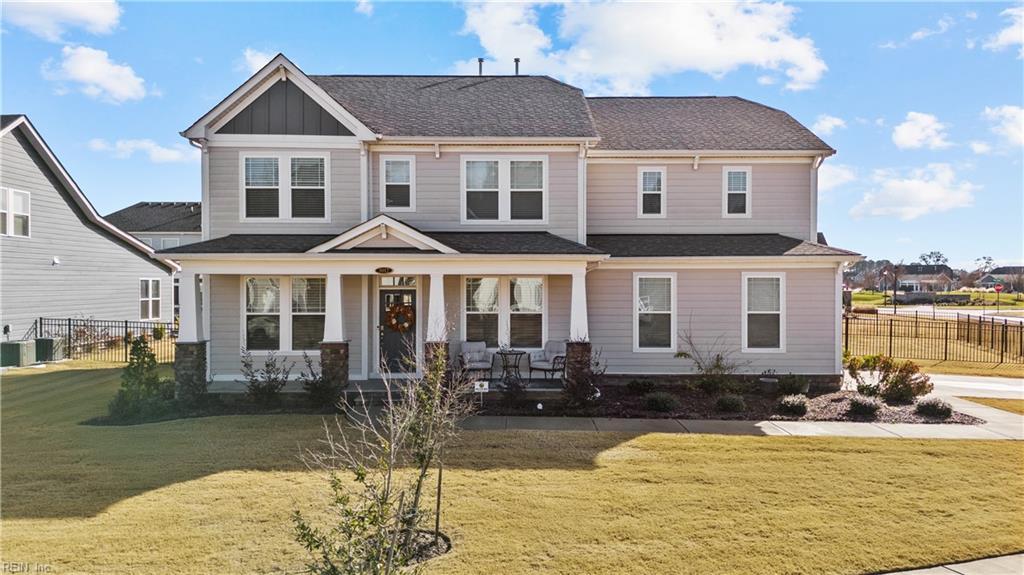 view of front of home featuring a porch, cooling unit, and a front yard