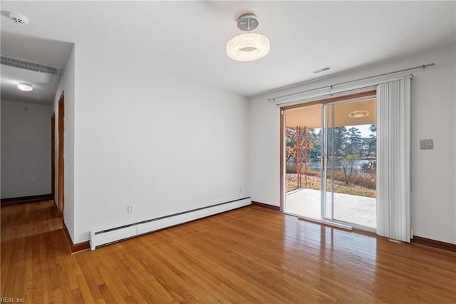 spare room with light hardwood / wood-style floors and a baseboard heating unit