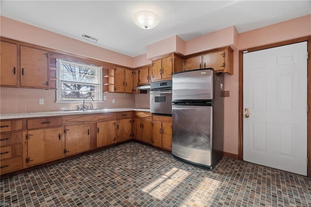 kitchen featuring decorative backsplash, sink, and stainless steel appliances